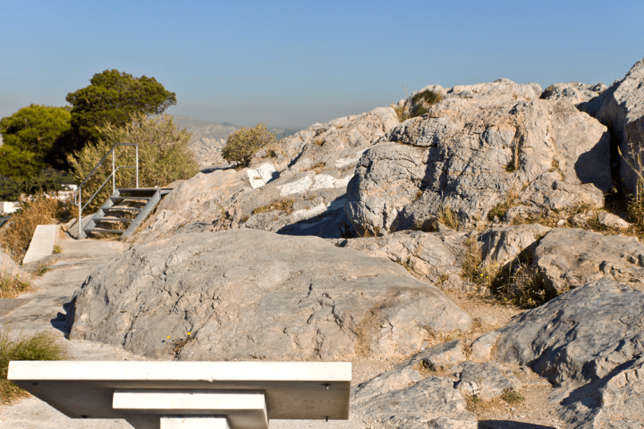 a bench in front of a rocky mountain