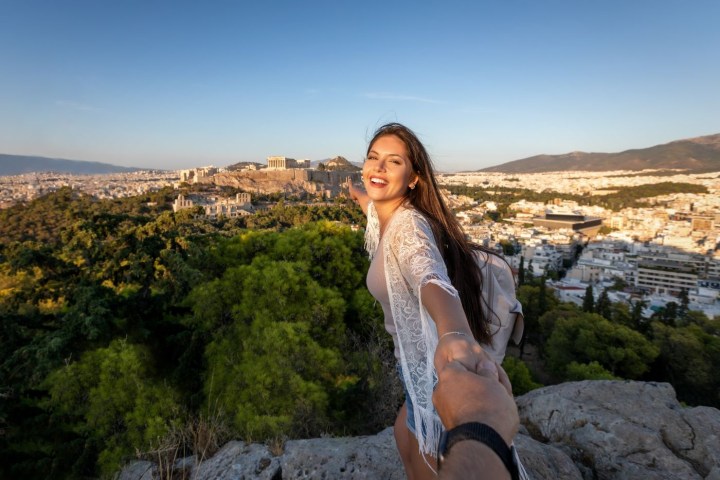 a woman standing in front of a rock