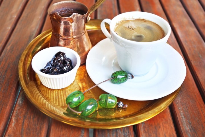 a cup of coffee sitting on top of a wooden table