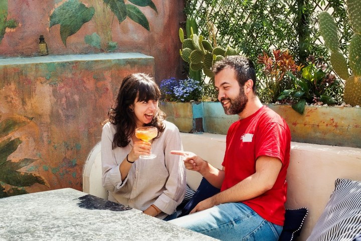a man and a woman sitting on a bench posing for the camera
