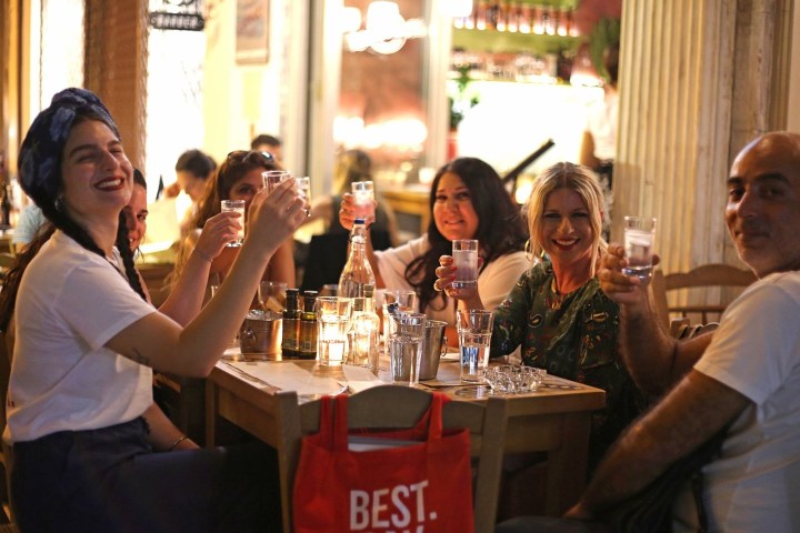 a group of people sitting at a table with wine glasses