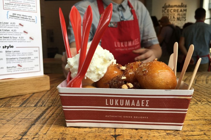 a person holding a box of donuts