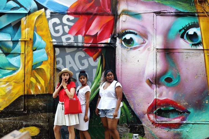 a person standing next to a body of water posing for the camera